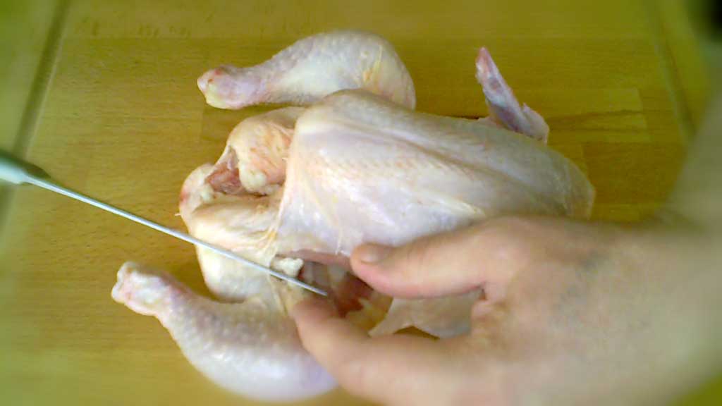 Splitting and dividing a chicken with a knife