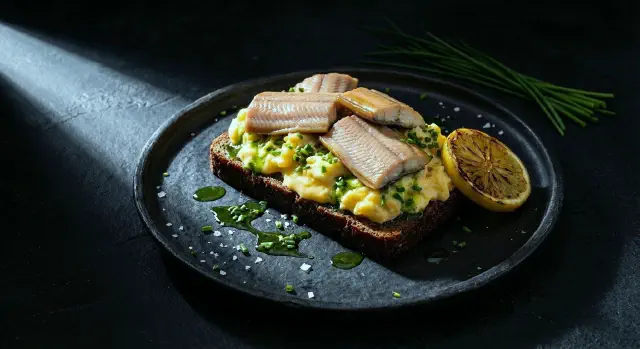 Smørrebrød with smoked eel, scrambled eggs and chive oil